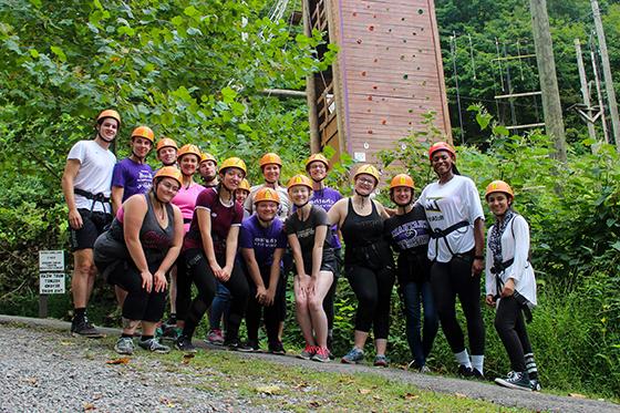 Photo of a group of Chatham University students at an obstacle course in the forest